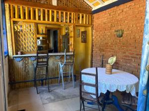 a room with a table and chairs and a bar at Casinha Rústica de Paty in Paty do Alferes