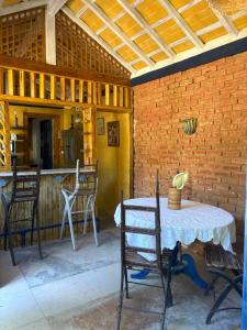 a patio with a table and chairs and a brick wall at Casinha Rústica de Paty in Paty do Alferes