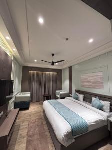 a bedroom with a large white bed and a desk at Hotel The Grand Mirage in Bathinda
