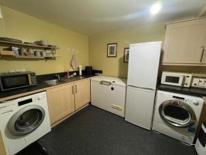a kitchen with a refrigerator and a washer and dryer at Riverview Colchester in Colchester