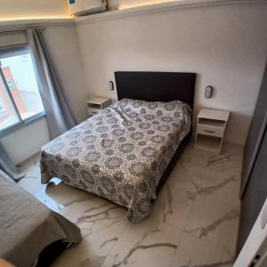 a bedroom with a bed and two tables and a window at Ein gutes Haus in Mina Clavero