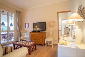 a living room with a couch and a tv at Le Sable Fin Beach House in Viareggio