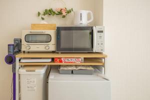 a microwave oven sitting on top of a refrigerator at night-night 東京ドーム便利 江戸川橋駅近 池袋銀座直通 商店街徒歩圏内 in Tokyo +32 photos