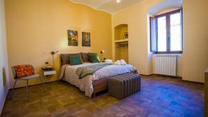 a bedroom with a bed and a chair and a window at Risorta Ponente in Boiano