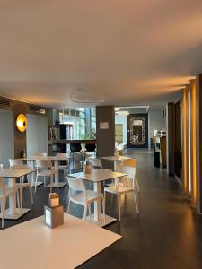 a restaurant with tables and chairs and a kitchen at Hotel Miramare in Sottomarina
