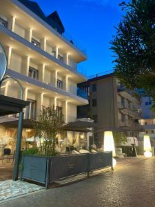 a large building with tables and chairs in front of it at Hotel Miramare in Sottomarina
