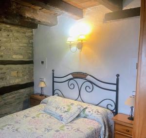 ein Schlafzimmer mit einem Bett und zwei Lampen an der Wand in der Unterkunft Casa Azón in Oliván