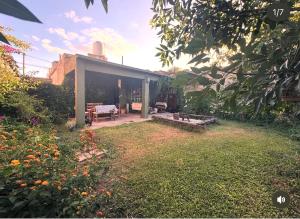 a backyard with a house with a patio and a garden at Casita Eureka in San Antonio de Areco