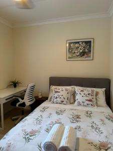 a bedroom with a bed and a desk with a computer at The Haven House in Singleton