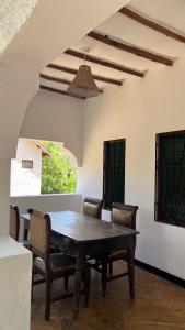 a dining room with a wooden table and chairs at 2 Bedroom serene cottage in Ukunda Airport +10 photos