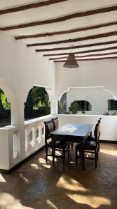 a dining room with a wooden table and chairs at 2 Bedroom serene cottage in Ukunda Airport