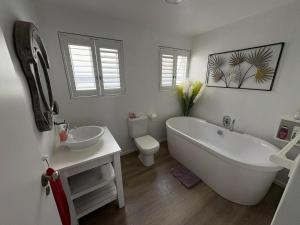 a bathroom with a tub and a sink and a toilet at The Windsock in Ballito +28 photos