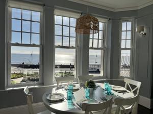 a dining room with a table and a view of the ocean at The Eastleigh in Seaton