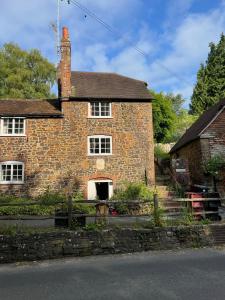 an old brick house with a gate in front of it at 4 St Richard’s Cottages in Fittleworth