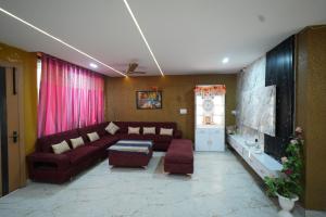 a living room with a couch and a tv at Hotel Konaaz Inn in Alīgarh