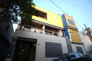 a yellow and blue building with a car parked in front at Hotel Konaaz Inn in Alīgarh