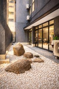 two large rocks sitting on a sidewalk in front of a building at 心斎橋難波関空直通Nambaminami direct to Shinsaibashi Ambers Hostel in Osaka