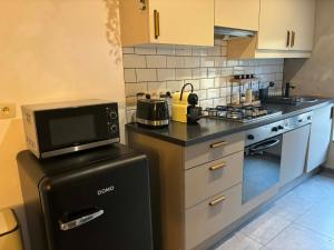 a kitchen with a black refrigerator and a microwave at Suite Sur Le Mont in Durbuy