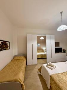 a bedroom with two beds and a television in it at Onda blu in Sant'Isidoro +32 photos