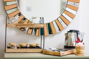 a shelf with glasses and a mirror on a wall at Rosie's Rest in Hunstanton