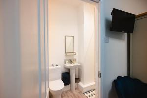 a bathroom with a white toilet and a sink at Rosie's Rest in Hunstanton +17 photos