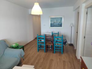 a living room with a table and two blue chairs at Apartment Núria in Bellreguart