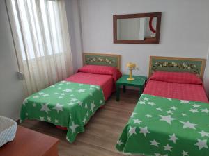 a bedroom with two beds and a mirror at Apartment Núria in Bellreguart