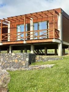 a wooden house with a stone wall at Salga Lodge in Angra do Heroísmo