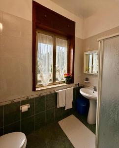 a bathroom with a sink and a toilet and a window at Onda blu in Sant'Isidoro