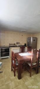 a kitchen with a wooden table with chairs and a refrigerator at Nossa casa in Petrópolis +34 photos