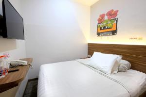 a hotel room with a bed and a tv at Front One Budget Malioboro Jogja in Yogyakarta