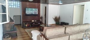 a living room with a couch and a tv at Nossa casa in Petrópolis