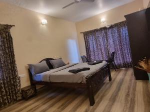 a bedroom with a bed and a large window at Honey Bee Cottages in Ooty