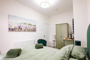 a bedroom with a bed and a painting on the wall at Rosie's Rest in Hunstanton