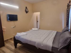 a bedroom with a bed and a flat screen tv at Honey Bee Cottages in Ooty