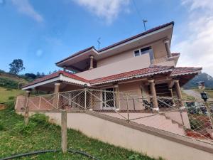 a house being constructed with a fence at Honey Bee Cottages in Ooty +6 photos