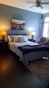 a bedroom with a bed with a blue wall at Shediac Beach Suite- Pointe du Chene Wharf and Parlee Beach in Pointe-du-Chêne