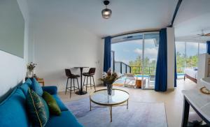 a living room with a blue couch and a table at Aura Koh Tao in Ko Tao