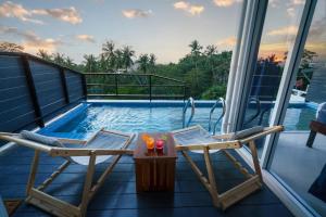 a balcony with two chairs and a swimming pool at Aura Koh Tao in Ko Tao