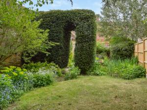 an arch covered in ivy in a garden at Teddy's Cottage in Market Overton