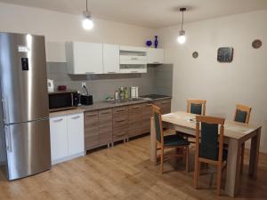 a kitchen with a table and a stainless steel refrigerator at Bungalov Mikulášovice in Mikulášovice