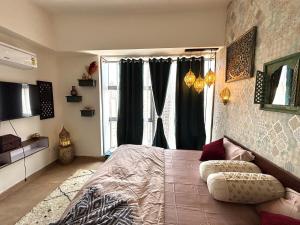 a bedroom with a bed and a large window at Royal Moroccan Escape in Noida in Noida