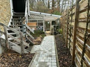 a garden with a brick walkway next to a building at Suite Sur Le Mont in Durbuy