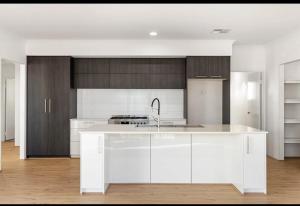 a white kitchen with a sink and a stove at Beach House Shared in Alkimos