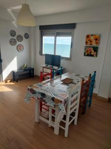 a dining room with a table and chairs and a computer at Apartamentos Guillem in Playa de Miramar