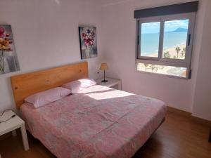 a bedroom with a bed and a window at Apartamentos Guillem in Playa de Miramar