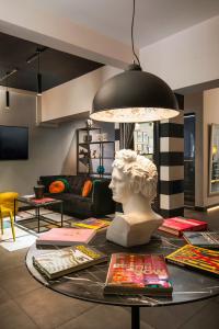 a room with a bust on a table with a lamp at The PopCity Hotel in Santiago