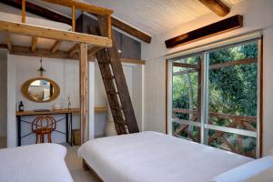 a bedroom with a loft bed and a mirror at サ郷 kakeRu 新旧アースバッグサウナ付 in Onna +49 photos