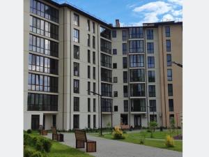 a large apartment building with benches in front of it at Апартаменты Сонячний квартал in Golubinoye