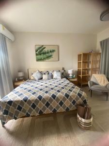 a bedroom with a bed and a chair at Apartamento Vacacional Coral Azul - SBH in Bayahibe